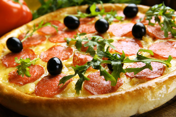 Tasty pizza with salami on decorated wooden table, close up