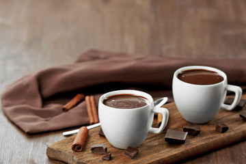 Cacao with sweets and cinnamon on cutting board