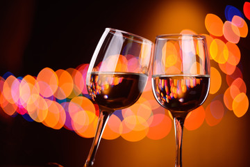 Two wine glasses clink at the party