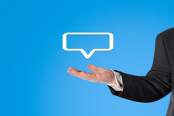 Businessman h&auml;lt eine virtuelle Sprechblase in der Hand