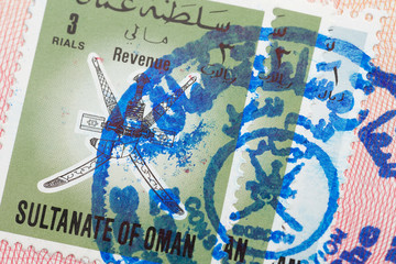 Passport page with the Sultanate of Oman visa and immigration control stamp.