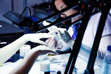 Manicure nail technician worker perfoming procedure for hand car