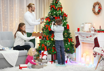 Obraz na płótnie Canvas Family decorating Christmas tree in home holiday living room