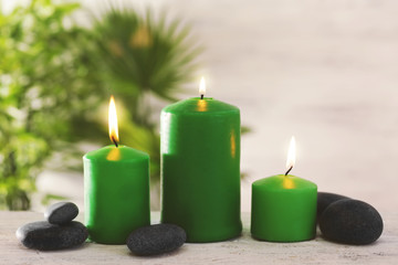 Green candles with spa stones and bamboo on table