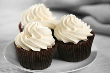 Tasty cupcakes on white saucer, close up