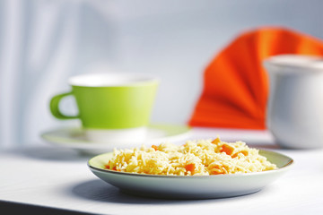 Stewed rice with a carrot on a plate