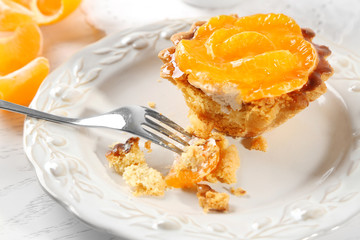 Sweet cake with tangerines on table, close up
