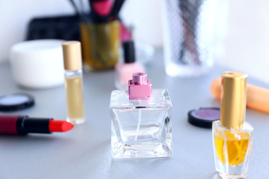 Perfume bottles with makeup tools and cosmetics on a table