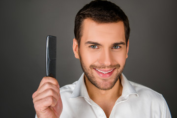 Cheerful man holding a comb