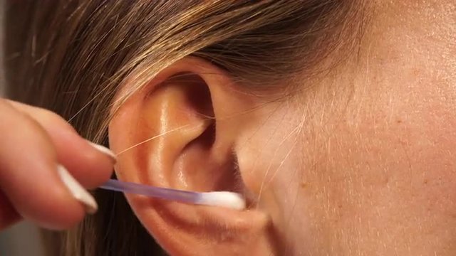 Woman cleaning ear with cotton swabs closeup 4K