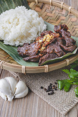 Deep fried marinated beef Thai Style on banana leaf with wood ba