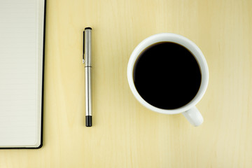 Office table with pen, notepad, cup of coffee. Top View