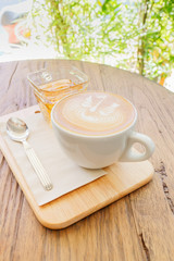 Cup of coffee latte art on wood table, selective focus