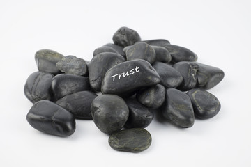 Black pebble with Trust word on white background