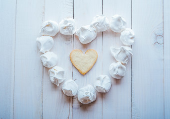 meringue laid out in the shape of heart and heart-shaped biscuits 