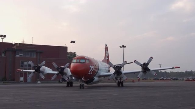 Tilt down from dawn sky to a Lockheed Orion transport plane parked at airfield.  Recorded in 4K, ultra high definition.