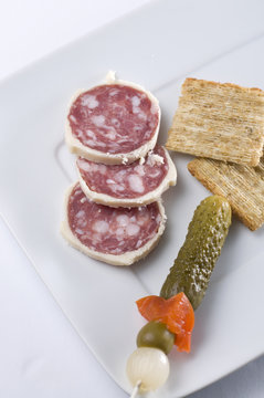 Vertical Shot of Salami with Pickle, Red Peppers and Crackers