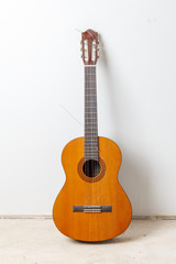 Fototapeta na wymiar Old classical acoustic guitar on white wall background