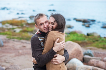 Loving couple hugging on the rocky beach