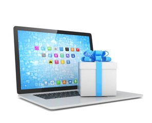 Gift box with ribbon bow on laptop keyboard