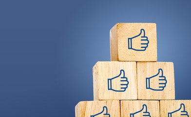 Thumb up icon on wood cube at dark blue background, leave space - obrazy, fototapety, plakaty