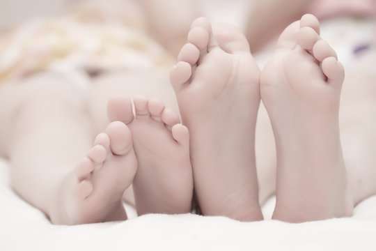 Two pairs of children's legs on the bed. The concept of a happy family.