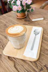 Fototapeta na wymiar Cup of coffee latte art on wood table