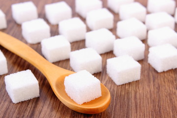 Cubes of sugar on wooden background, ingredient for cooking