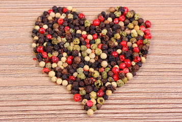 Heart of fresh colored pepper on wooden background