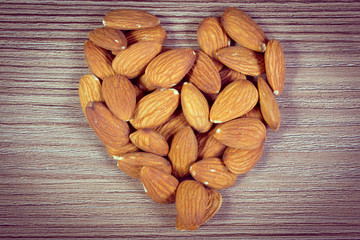 Vintage photo, Heart of almonds on wooden background