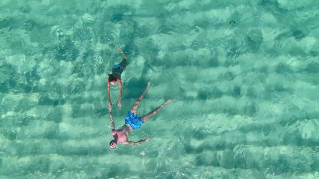 Aerial view of couple swimming in caribbean sea