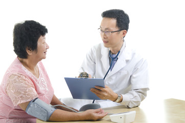 Image of a doctor and his nurse checking up a senior patient in