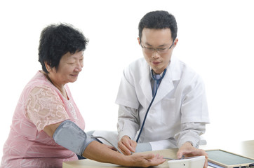 Image of a doctor and his nurse checking up a senior patient in