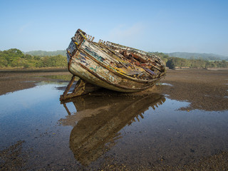 Boat wreck in Dulas estuary, Anglesey with reflection on a misty morning.