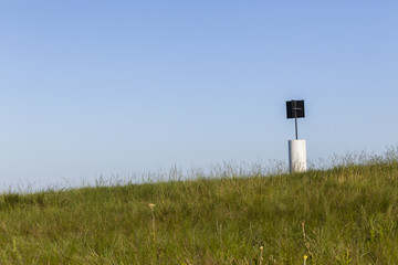 Hilltop Beacon Marker structure mapping landmarks on rural hilltop summer landscape