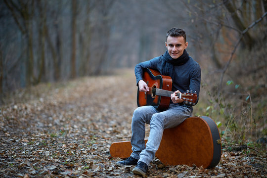 Guitarist singing outdoor in the forest