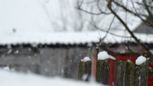Falling snow on the background of the fence