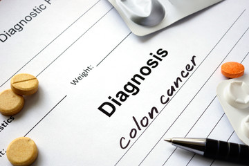 Diagnosis colon cancer written in the diagnostic form and pills.