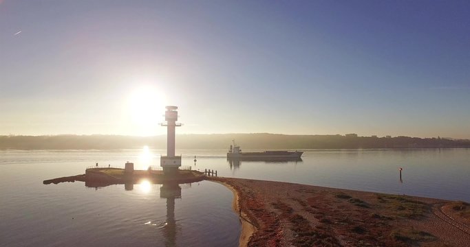 aerial view of an beach in the morning sun with an lighthouse