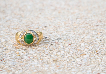 Closeup old green jade ring on blurred stone floor background