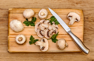 Mushrooms cut on a board with a knife