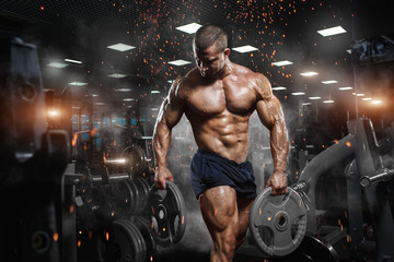 Fototapeta Muscular athletic bodybuilder fitness model posing after exercises in gym obraz