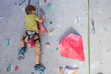 little boy climbing a rock wall