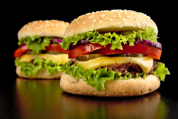 Big two cheeseburgers isolated on black background
