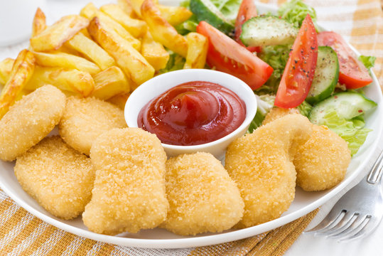 fast food lunch with chicken nuggets, french fries and salad