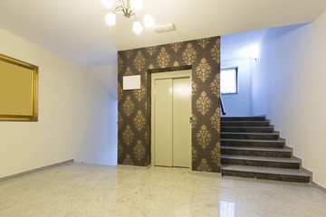 Hotel lobby interior with elevator and stairs