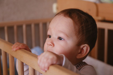 Curious child, standing in the child's bed