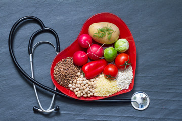 Healthy food on red heart plate cholesterol diet concept
