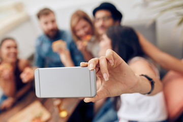 Woman taking a selfie at party with friends