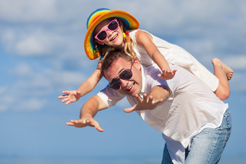 Father and daughter playing on the beach at the day time.